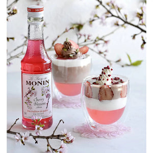 Close-up of Monin Sakura Syrup, 700ml, featuring light pink hue for elegant drinks