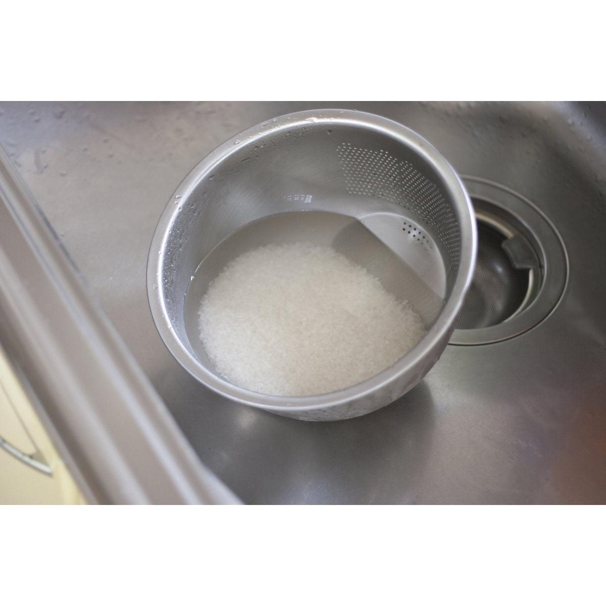 Close-up of Stainless Steel 3-Way Rice Washing Bowl With Strainer, featuring drain holes for efficient straining