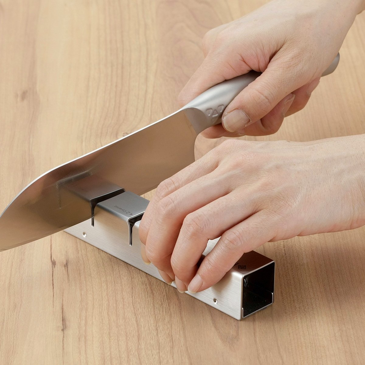 Handheld Shimomura knife sharpener with diamond and ceramic slots, designed for everyday kitchen use